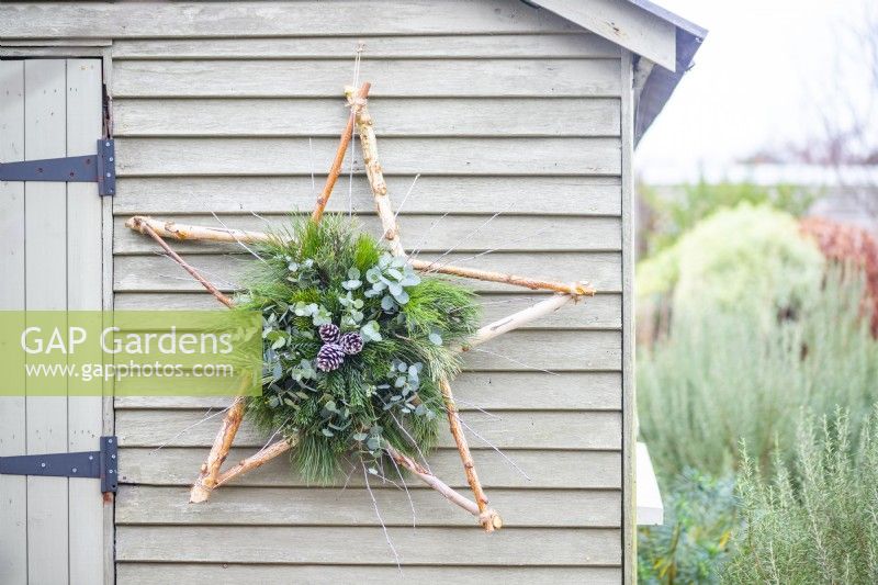 Decorative star hanging on a pale green wooden wall