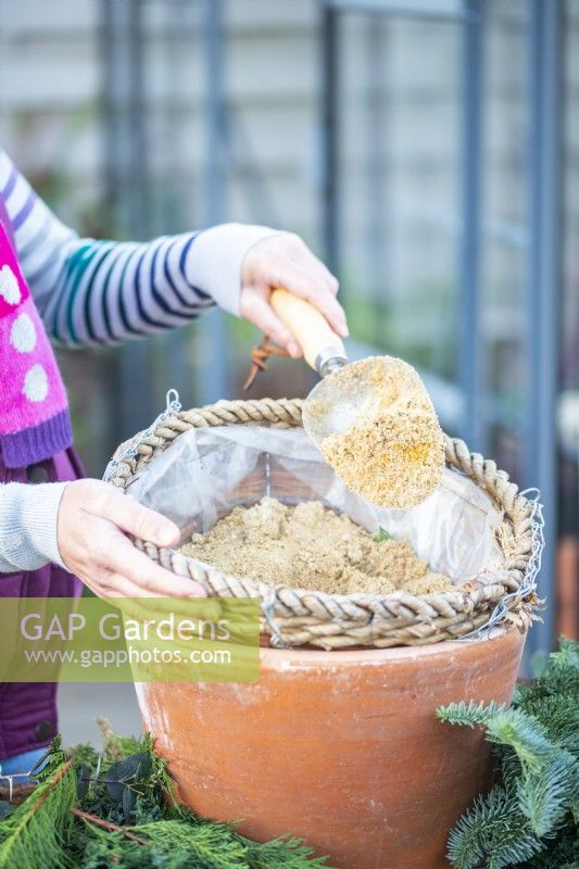 Woman adding sand to the hanging basket