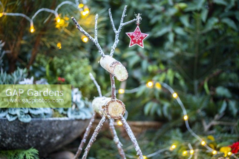 Birch reindeer with a star ornament hanging from its antler