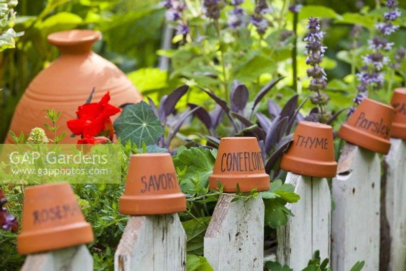 Terracotta pot labels on a fence in the kitchen garden.