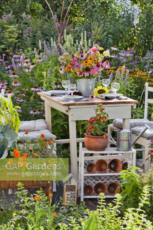 Summer floral table decoration. Bucket with Rudbeckia, Echinacea purpurea, Monarda, Dahlia, Agastache and Nepeta kubanica.