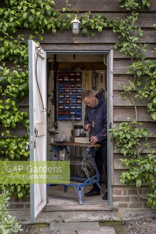 View into shed with man working at a bench
