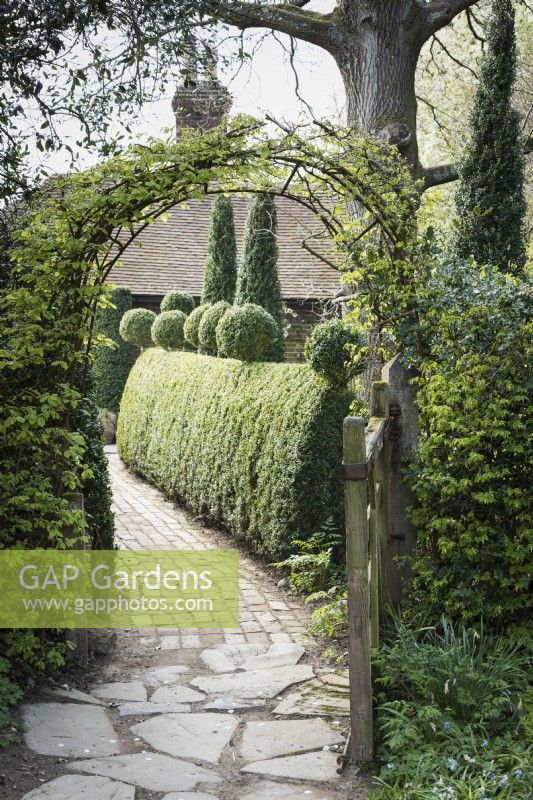 Path into the garden at Balmoral Cottage, Kent in April with stone and brick setts. 