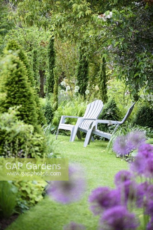A pair of loungers in a country garden in June