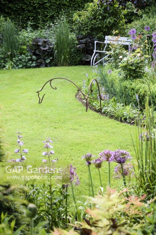 Pair of metal leaping foxes in a June garden