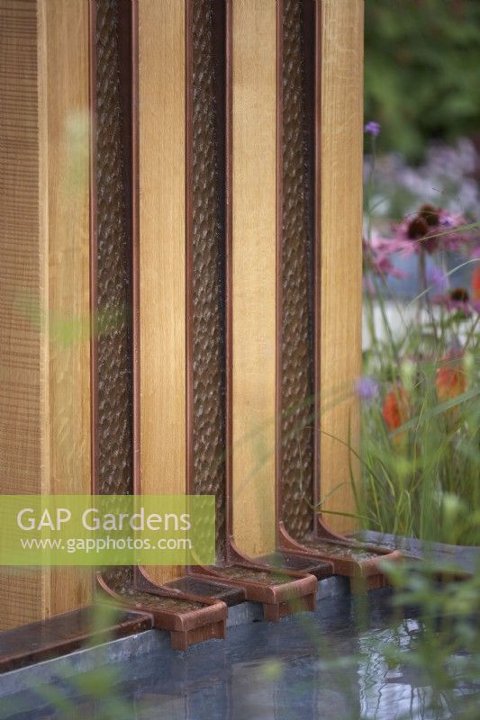 Finding Our Way: An NHS Tribute Garden. Detail of vertical waterfall 'rills' emptying into a shallow pool. Designer: Naomi Ferrett-Cohen. RHS Chelsea Flower Show 2021.