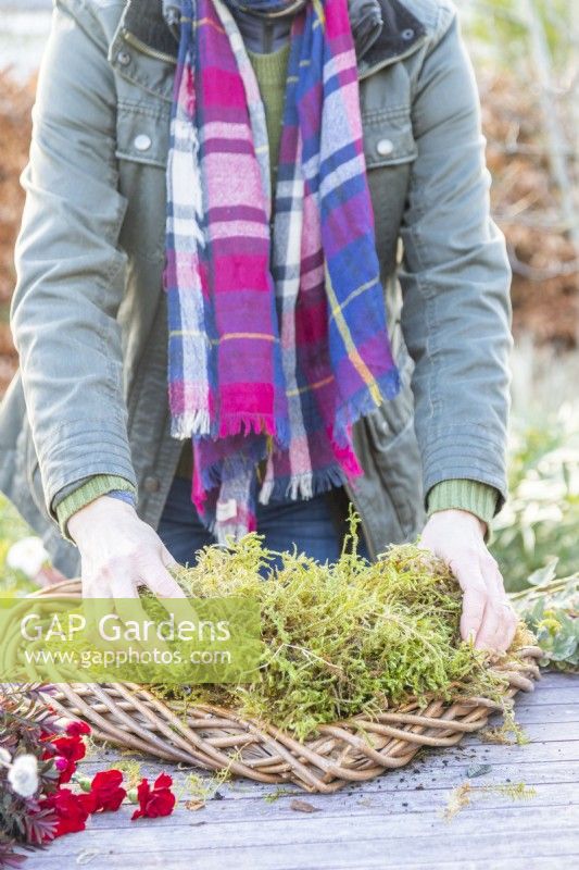 Woman placing moss around the base of the wreath