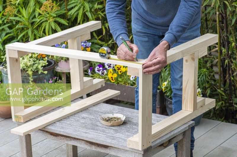 Step-by-Step Making a Potting Bench. Step 6: marking the screw holes for attaching the front panels to the top of the frame, thereby connecting the two side frames