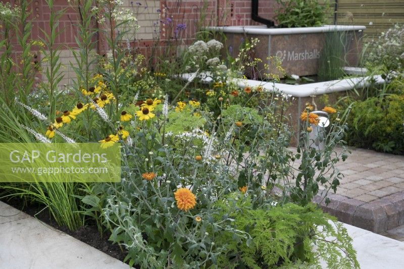 'The Marshalls Garden' at BBC Gardener's World Live 2021 - urban garden using many contrasting hard landscaping products with a two tier water feature bordered by perennials