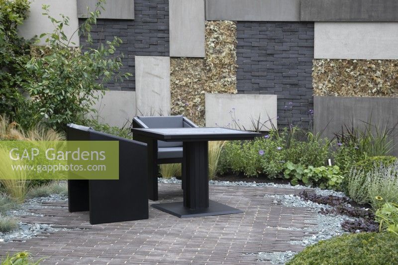 'Shades of Grey' at BBC Gardener's World Live 2021 - urban contemporary garden using different grey hard landscaping materials on both the path and the retaining wall