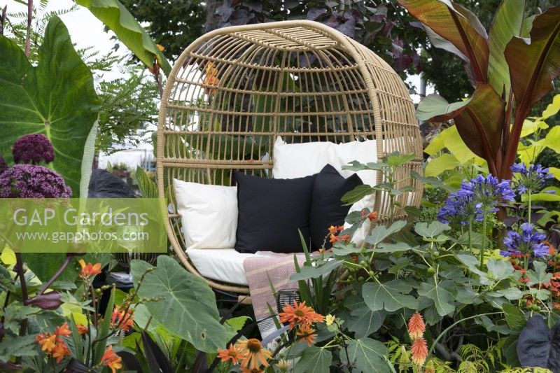'Garden Envy' at BBC Gardener's World Live 2021 - egg seat bordered by mixed exotic planting 