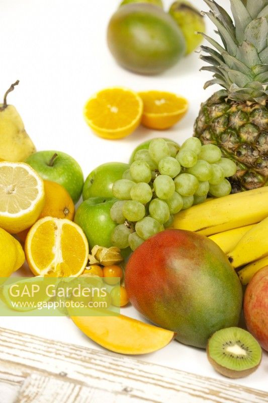 Fruit mix with grapes, pineapple, mango, bananas, apples, lemon and more, summer June