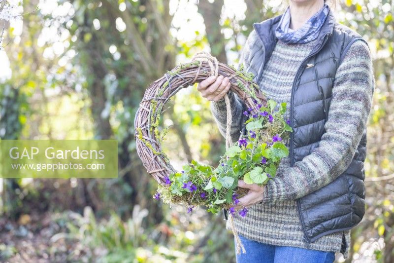 Woman holding the viola and lichen wreath