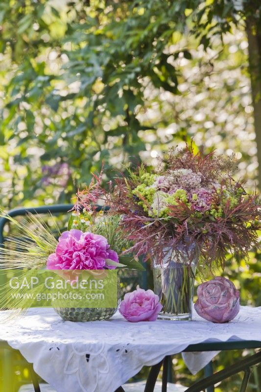 Floral arrangement with peonies, roses, heuchera and Japanese maple foliage.