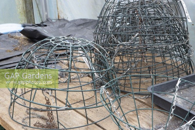 Wire baskets for hanging baskets stored at a commercial nursery. Stacked storage.