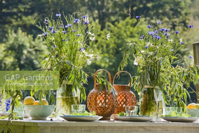 Table place setting with wildflower bouquets in vases.