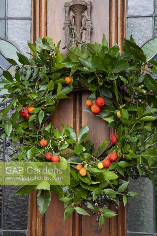 Christmas Wreath on front door, 
Arbutus fruit, Strawberry Tree, Bay foliage Myrtus Myrtle berries and foliage on wicker circle, scented leaves and berry December 