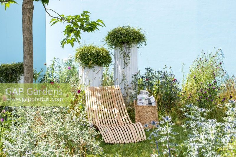 Curved reclinging chair in the Garden of Solitude, RHS Hampton Court Palace Garden Festival 2021. Design: Carlotta Montefoschi, Niccolo Cau, Ricardo Walker Campos.  Sponsor: Laboratorio S. Rocco