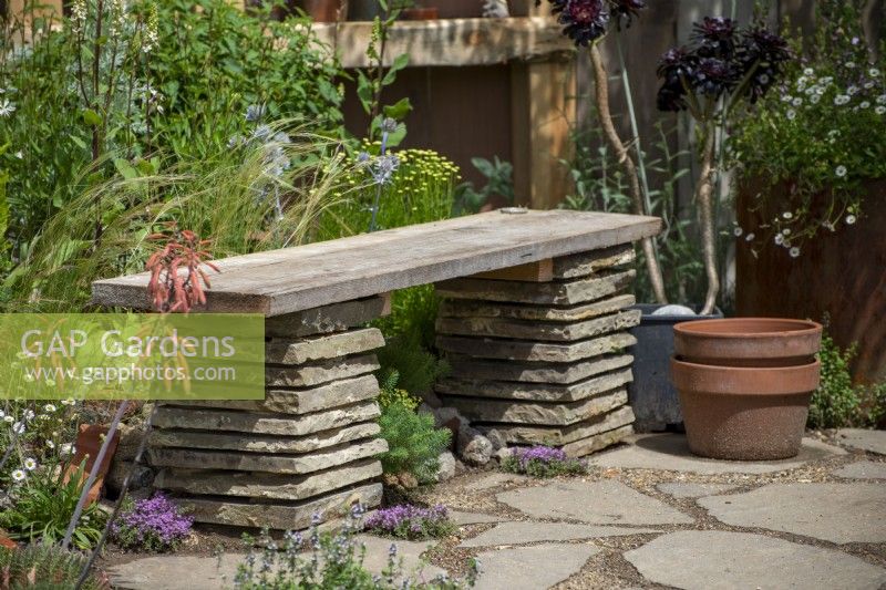 Punk Rockery Garden, RHS Hampton Court Palace Garden Festival 2021.  DIY bench made from paving slabs and scaffold board