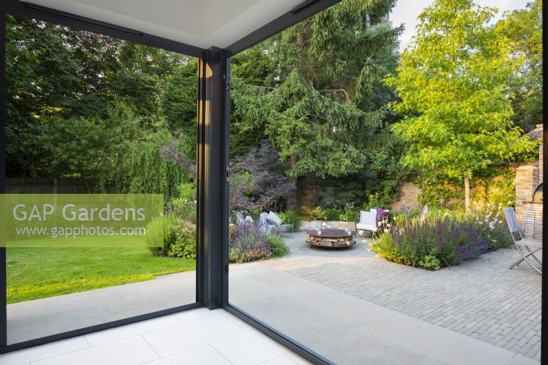View through the open doors from indoor kitchen extension to the sunken garden.