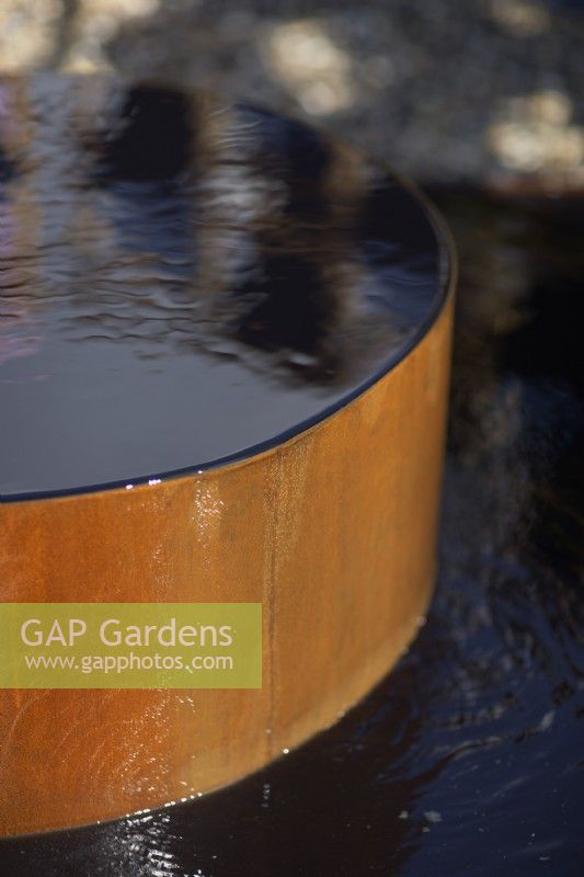 The Fashion Footprint Garden. Designer: Baz Grainger. A water feature made of corten steel. RHS Hampton Court Palace Garden Festival Show 2021
