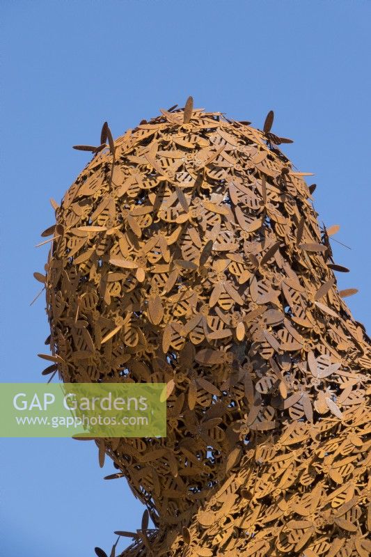 Giant figure detail head covered with 10,000 bees made of Corten steel designed by Florentijn Hofman named Beehold.