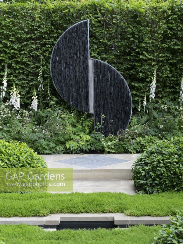 RHS How Garden - A garden designed With Love detail of sculpture amid white and green planting