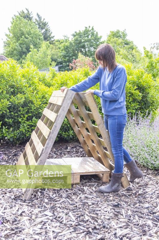Woman positioning the pallets to form a triangle