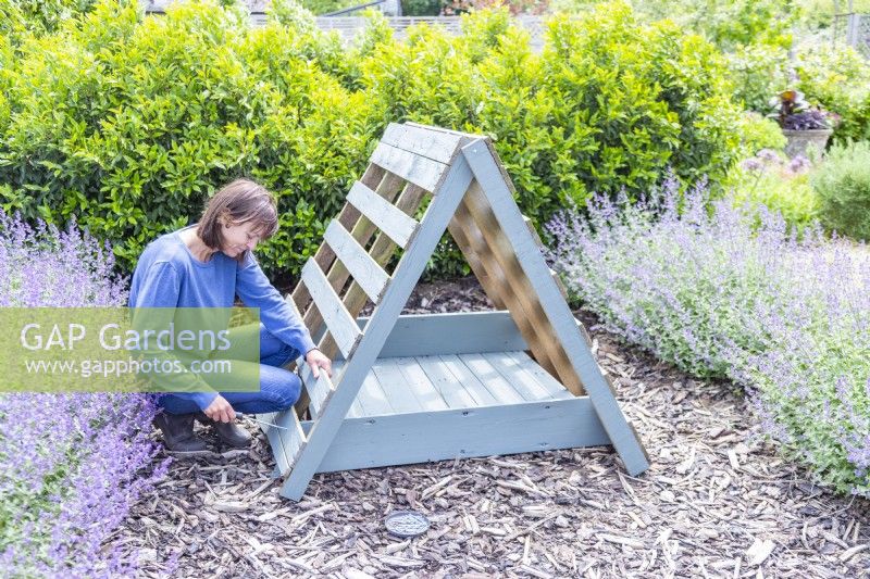 Woman screwing the wooden planks to the pallets