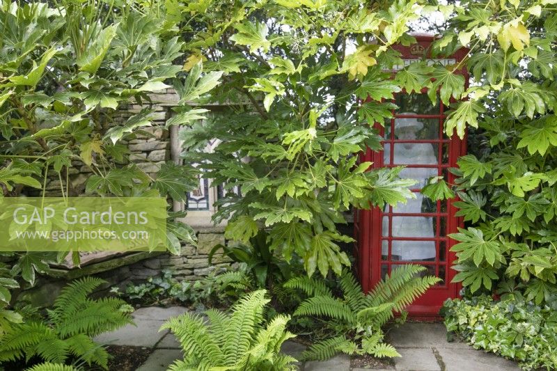 The Queen in a red phonebox in the Folly - a shady seating area at Hamilton House garden in May 