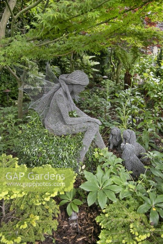 Wire sculpture of a fairy with three small dogs by Derek Kinsett at Hamilton House garden in May 