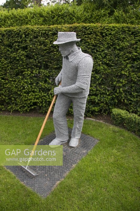 Wire sculpture of a man gardening by Derek Kinzett in the front garden at Hamilton House garden in May 