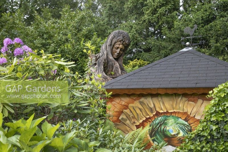 Blodeuwedd wooden sculpture at Hamilton House garden in May 