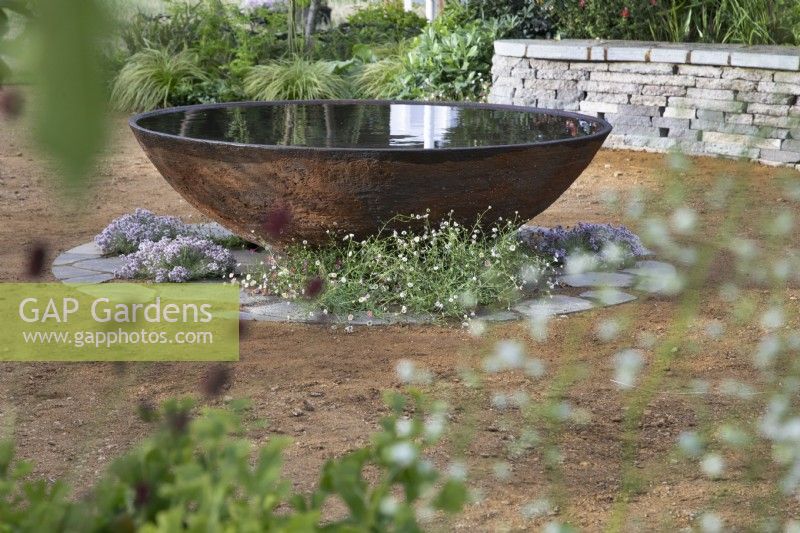 Circular corten steel water feature in the RHS Planet-Friendly Garden at RHS Hampton Court Palace Garden Festival 2022