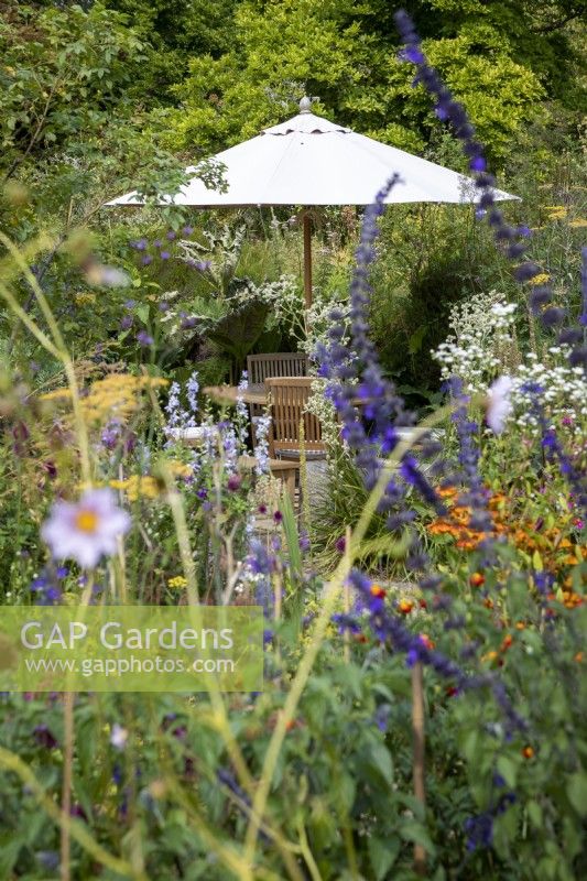 Parasol and garden furniture in a cottage garden