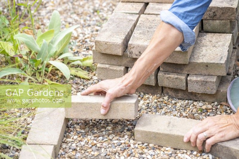 Woman placing pavers in a wedge shape