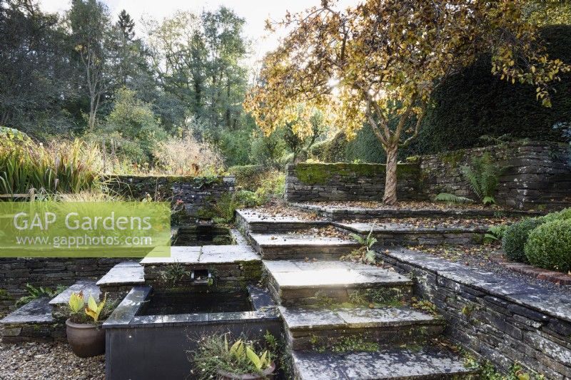 Stepped terraces with water feature in a country garden in November