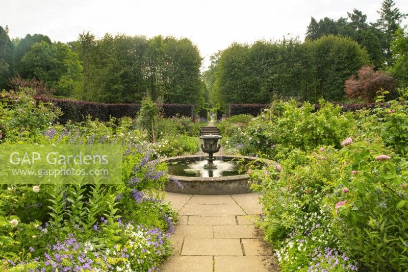 An urn shaped fountain and circular water feature in the center  of the rose garden at Newby Hall.