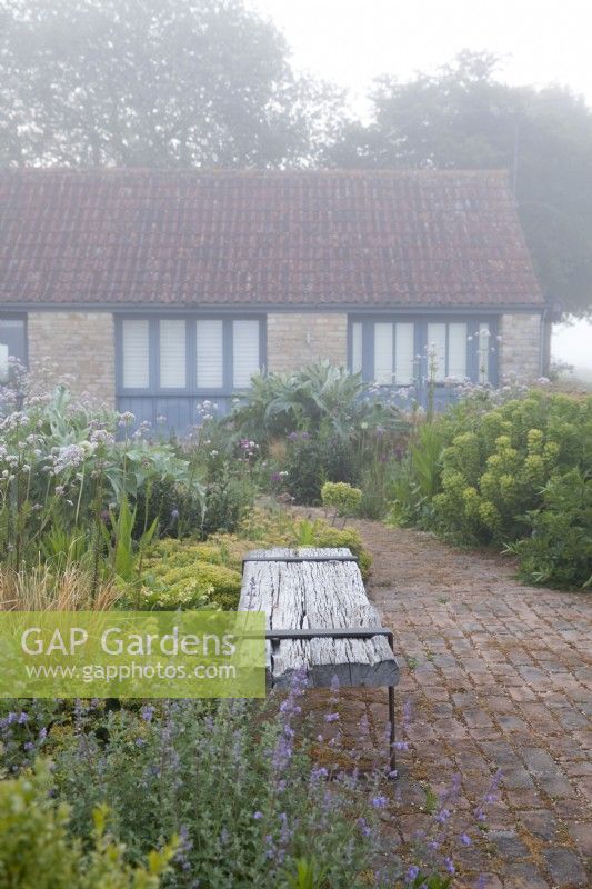 Rustic wooden bench on a misty morning, Hailstone Barn, Gloucestershire.  