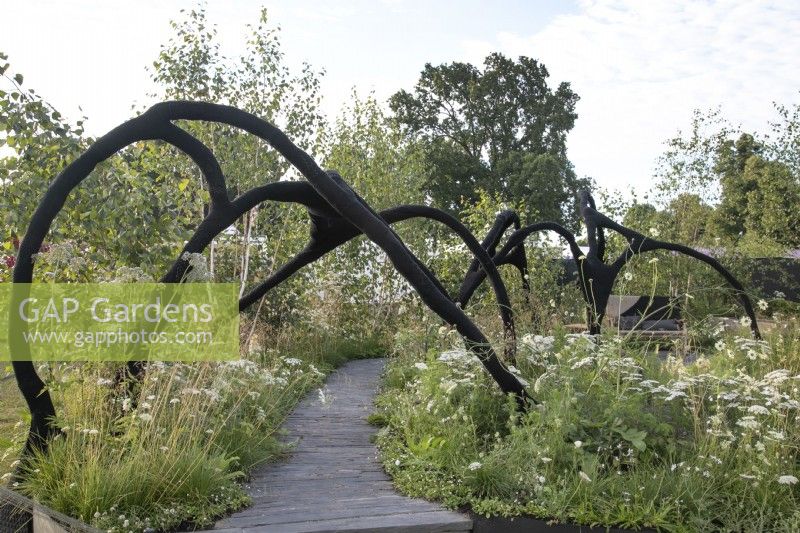 Black yarnbombed walkway in the Connections garden at RHS Hampton Court Palace Garden Festival 2022
