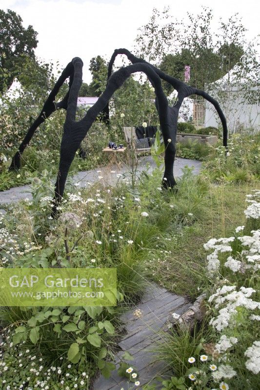 Black yarnbombed walkway in the Connections garden at RHS Hampton Court Palace Garden Festival 2022