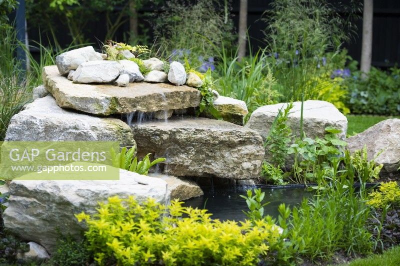 Garden waterfall built with stone boulders. 
