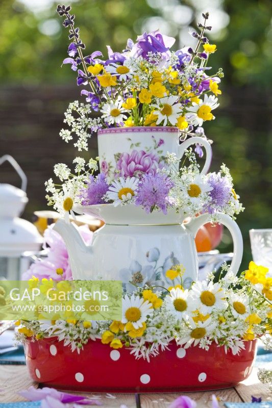 Floral arrangement containing oxeye daisies, buttercup and field scabious.