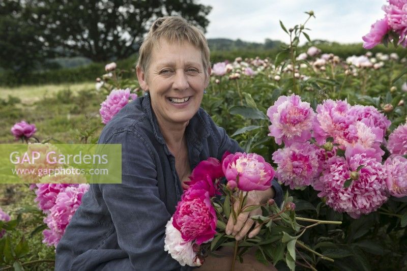 Claire Austin with Paeonia blooms in her nursery field