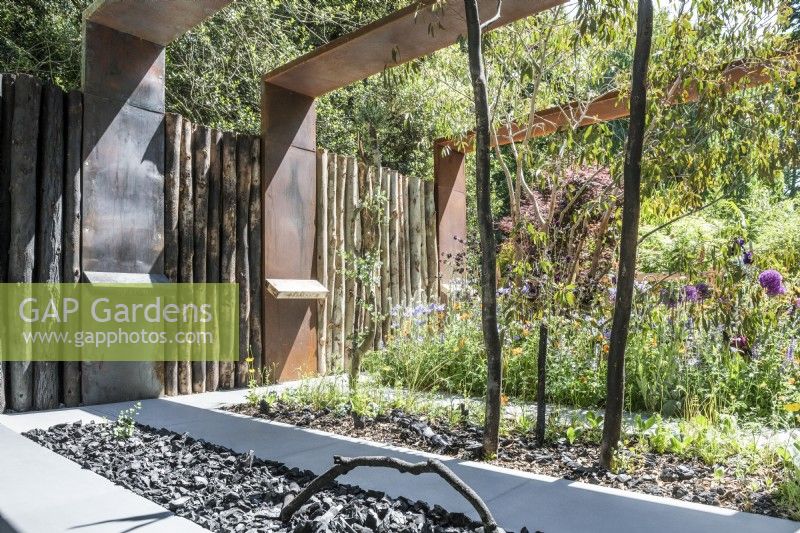Beds with charcoal and charred wood and regenerating fire damaged Eucalyptus dalrympleana.

The Body Shop Garden 

Designer: Jennifer Hirsch

RHS Chelsea Flower Show 2022 Sanctuary Gardens