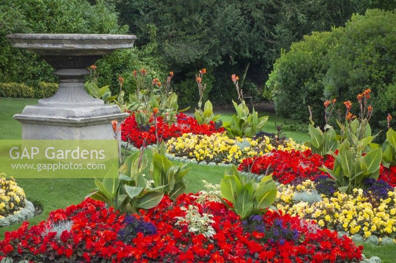 Bedding plants by a large stone urn 