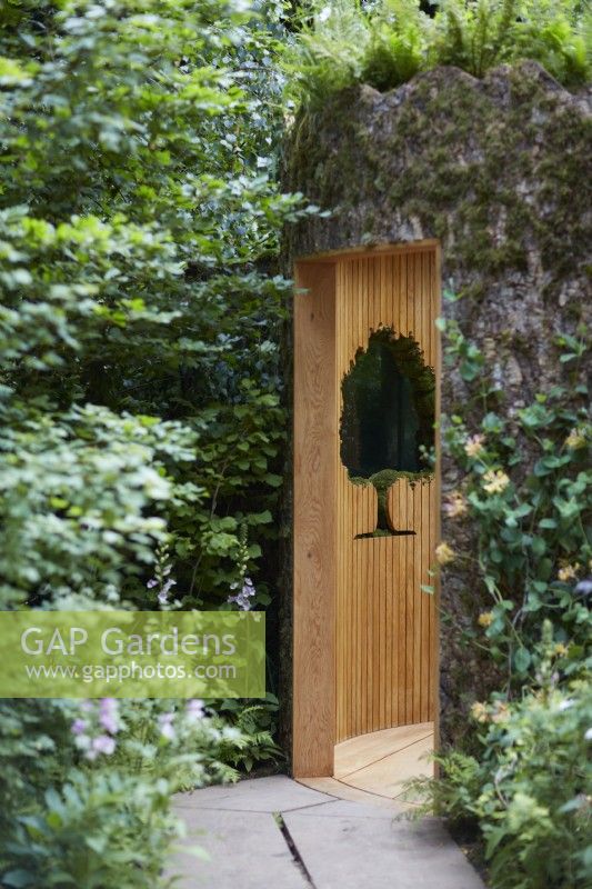 Connected, By Exante. Designer: Tonia Suonio. RHS Chelsea Flower Show 2022. Silver Gilt Medal. Carving of Oak Tree edged with moss in building wall seen through doorway.