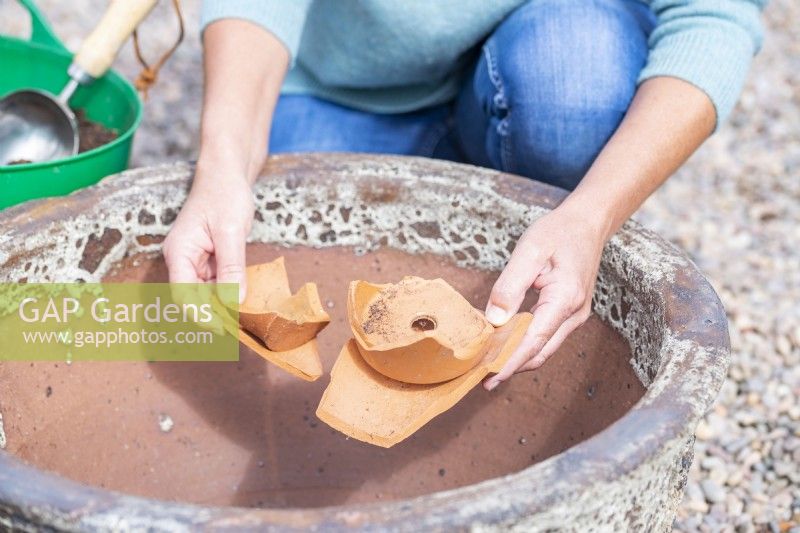 Woman placing crocks in large container