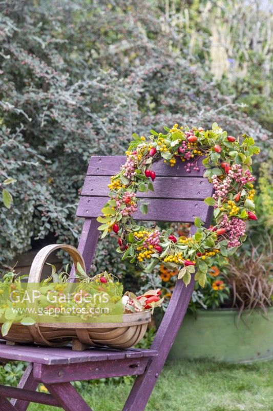 Wreath and trug full of materials used on a wooden chair