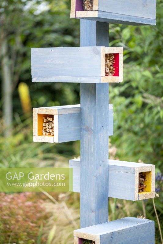 Home-made painted bug hotel in a garden